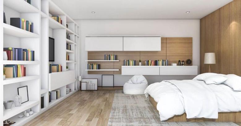 keeping the built-ins that come with your home will help make it seem larger because it doesn't take up floor space. In this image we see a bedroom that has a whole wall that is a built in with books on the shelves.